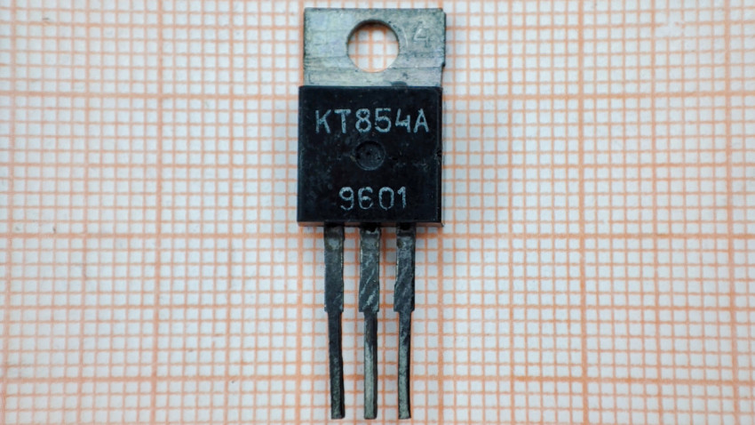 Транзистор КТ854А на фоне миллиметровой бумаги