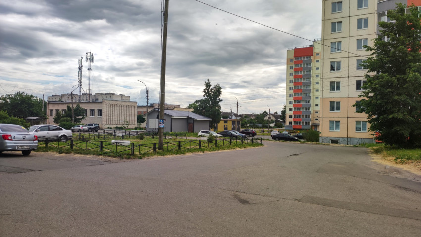 Улица в городе с многоэтажными домами и облачным небом