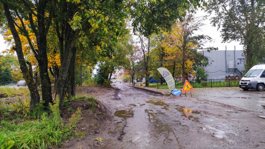 Осенняя дорога с предупреждающими знаками в городской зоне