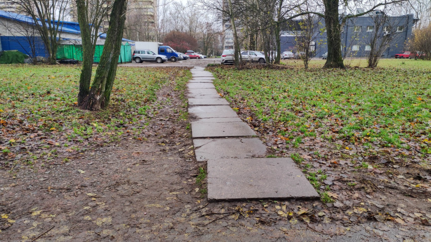 Пешеходная дорожка во дворе из бетонных плит на грунтовом покрытии