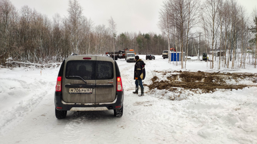 Автомобиль Lada Largus на зимней стройке с рабочими и техникой