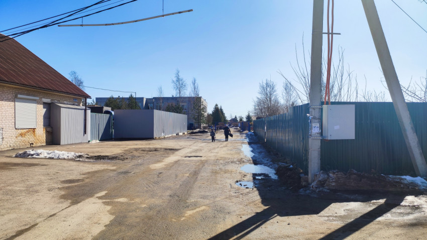 Загородная улица с застройкой и временным ограждением