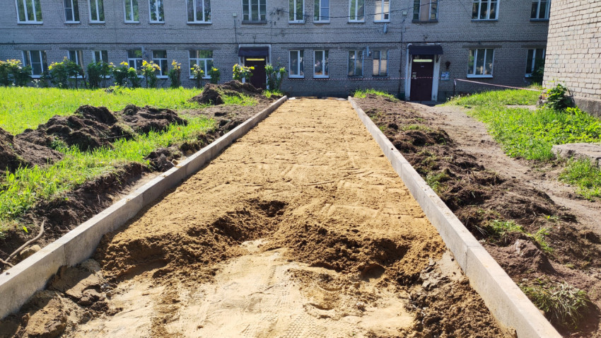 Песчаная подготовка и бордюры перед многоквартирным домом
