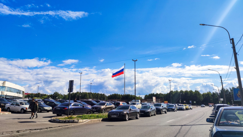 Российский флаг над парковкой автомобилей