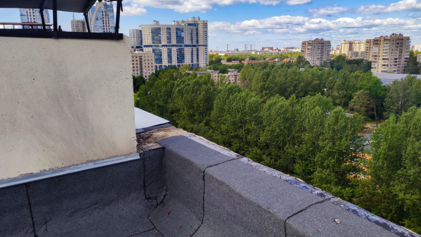 Угол крыши с парапетом и видом на жилые кварталы