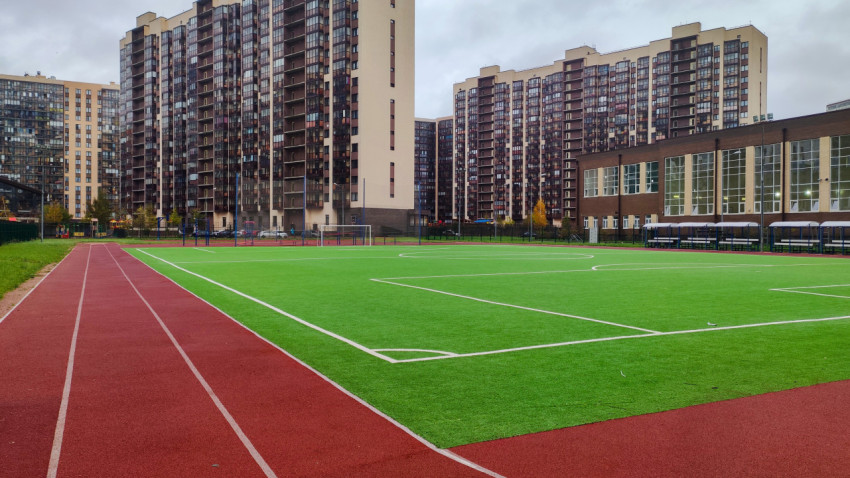 Беговая дорожка вдоль футбольного поля в жилом квартале