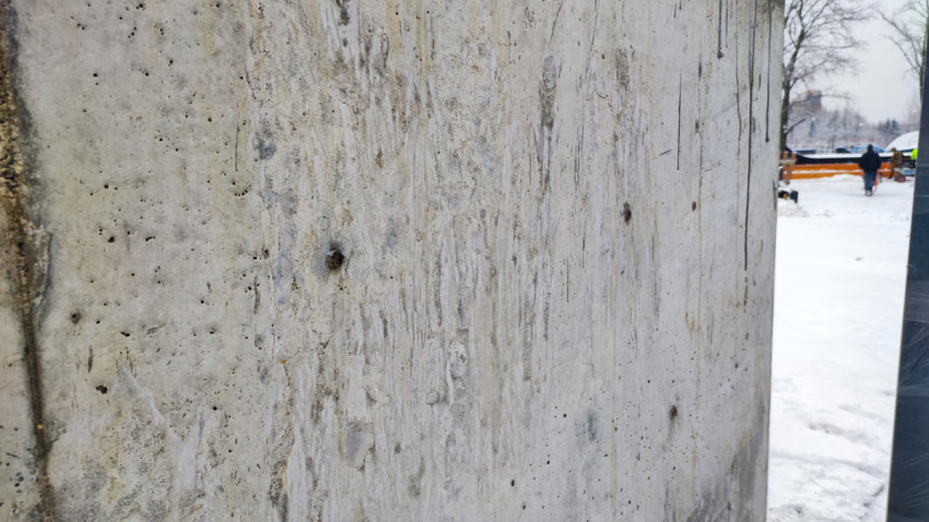 Бетонная стена с дефектами поверхности в зоне скейтпарка