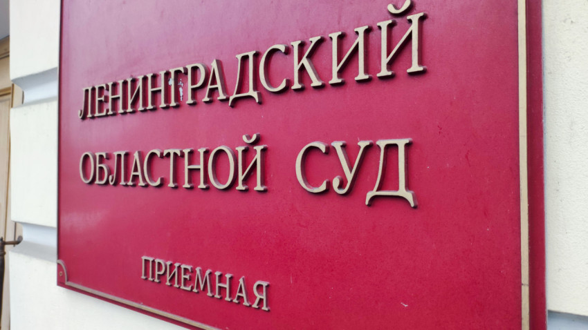 Красная табличка приёмной Ленинградского областного суда на стене