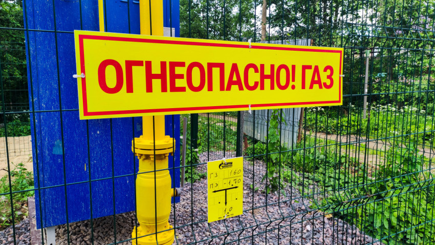 Предупреждающий знак «Огнеопасно! Газ» на фоне желтого газопровода и синей панели