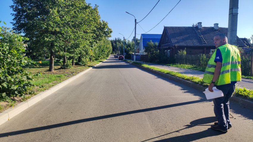 Специалист в сигнальном жилете осматривает дорогу и делает пометки на месте