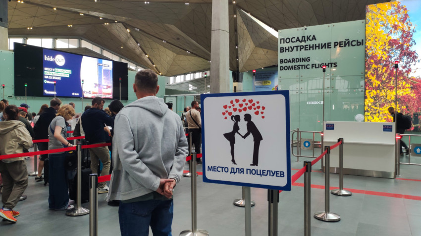 Очередь на посадку внутренних рейсов и табличка «Место для поцелуев»