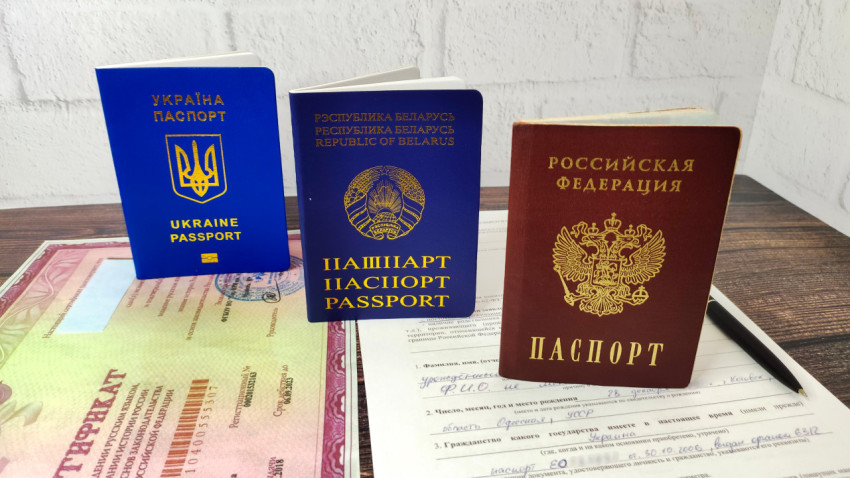 Паспорта Украины, Беларуси и России на фоне сертификата о владении русским языком