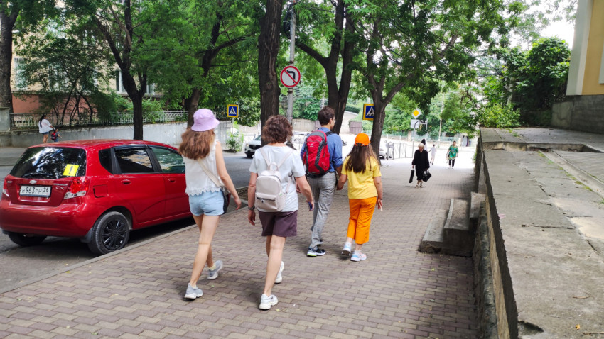 Группа молодых людей гуляет по улицам Кисловодска в солнечный день