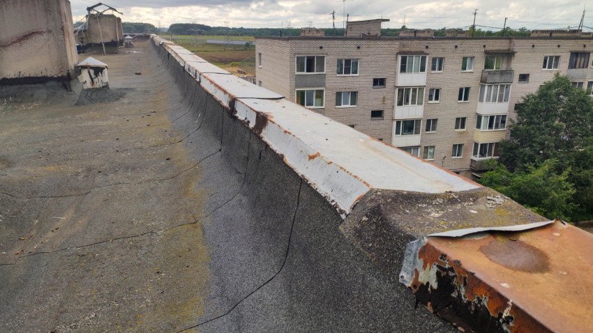 Поврежденный парапет и изношенная кровля многоквартирного дома
