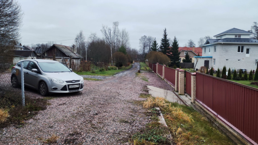 Загородная улица с частными домами и автомобилем