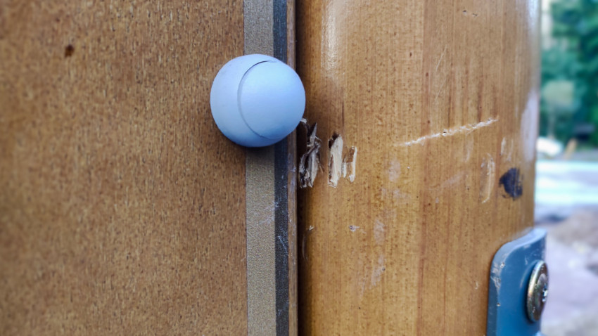 Повреждение поверхности стойки детской площадки у точки крепления