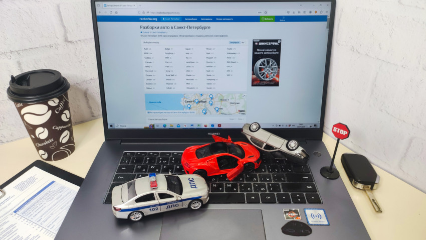 Игрушечные автомобили и ноутбук Huawei с сайтом автозапчастей