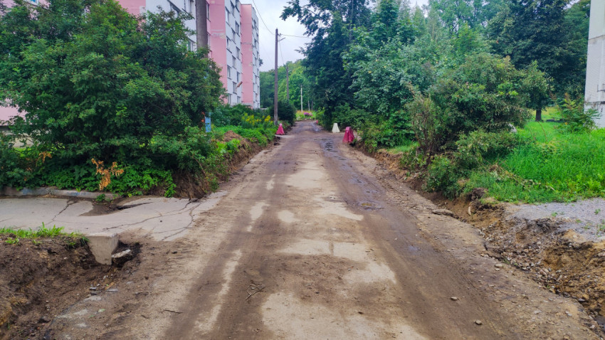 Дворовая дорога после снятия покрытия с вырытыми краями и временными конусами