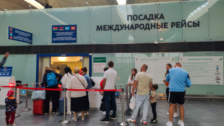 Очередь к международной посадке у стенда с правилами и указателями