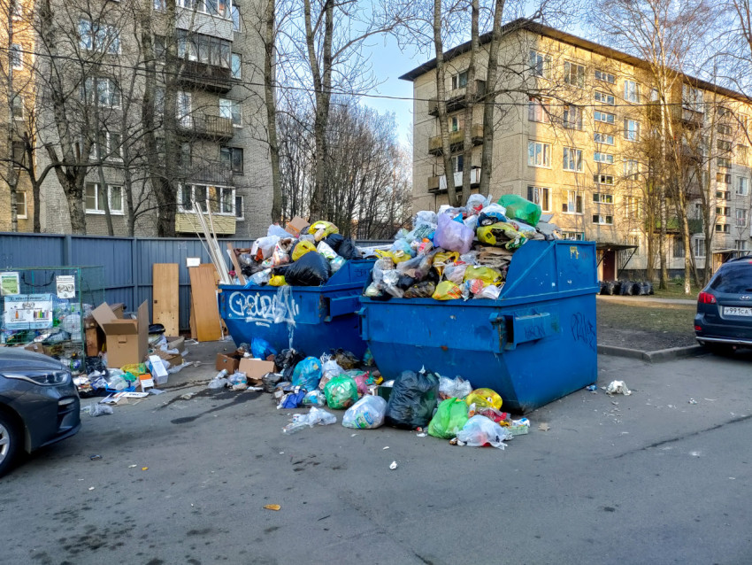 Переполненные мусорные контейнеры во дворе жилого района