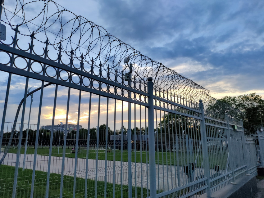 Охранное ограждение с колючей проволокой вдоль территории