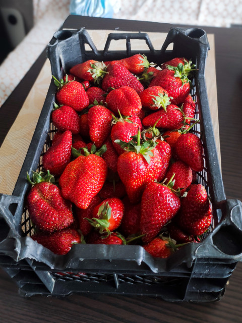 Ящик со свежей клубникой в домашней обстановке