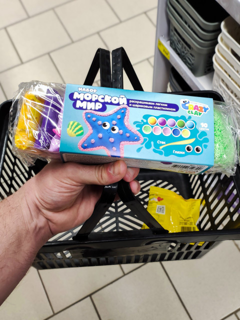 Набор детского пластилина Crazy Clay «Морской мир» лежит в руке над магазинной корзинкой