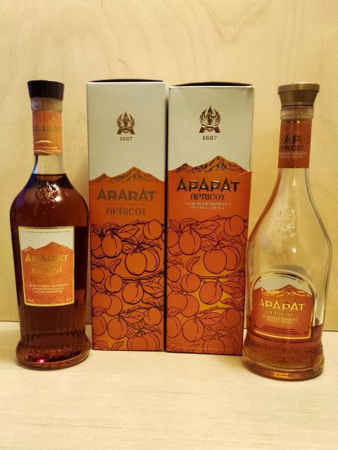 Бутылки и коробки армянского напитка Ararat Apricot на фоне светлого дерева