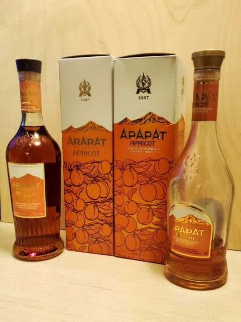 Армянский коньяк Ararat Apricot с фирменной упаковкой на деревянной поверхности