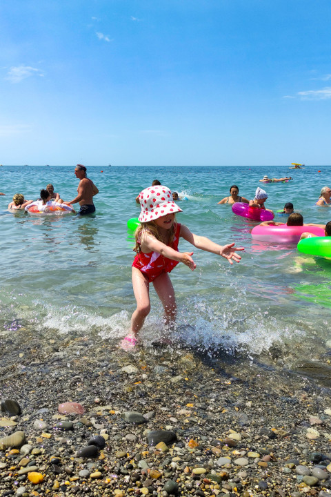 Девочка играет на берегу моря в летний день