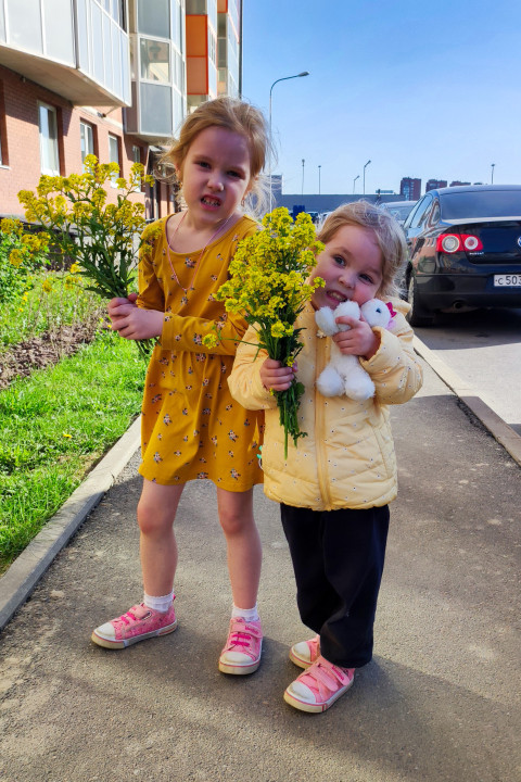 Дети с букетами цветов на пешеходной дорожке