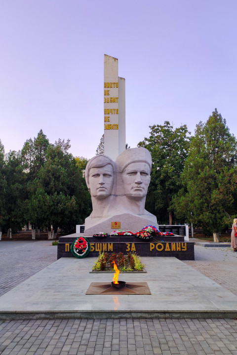 Вечный огонь у мемориала «Павшим за Родину» в Прохладном на фоне памятной стелы