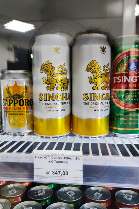Импортное пиво Singha, Sapporo и Tsingtao в холодильной витрине с ценником в рублях