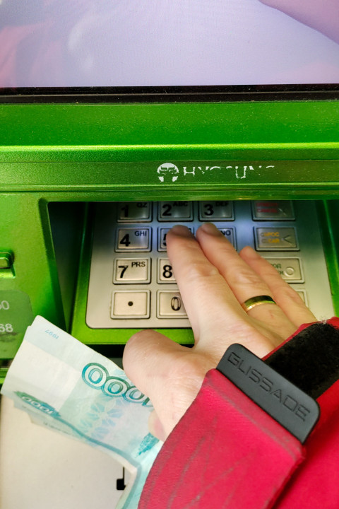 Клиент вводит PIN-код на банкомате Сбербанка