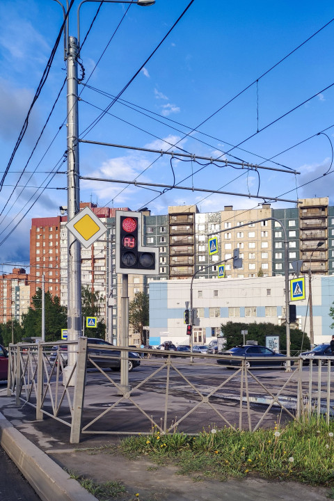 Светофор с красным сигналом, знак приоритета и городская среда