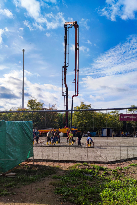 Рабочие выравнивают бетон у стройплощадки под открытым небом