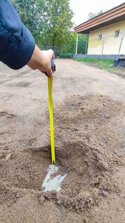 Измерение глубины песчаного слоя рулеткой при строительном контроле