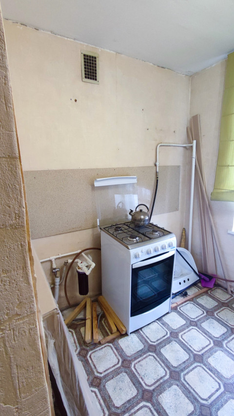 Угол кухни с газовой плитой и вентиляционной решёткой
