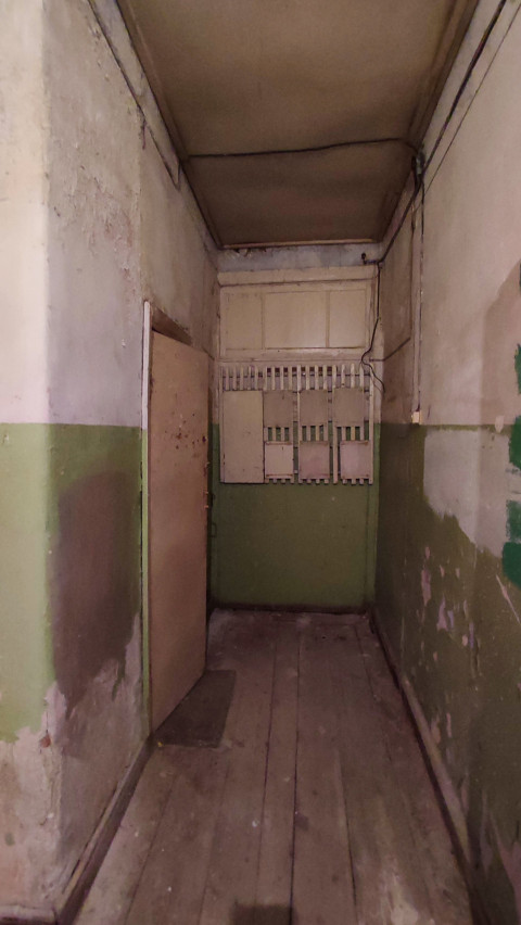 Узкий коридор с электрощитами и проводкой в старом помещении