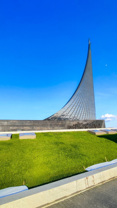 Монумент «Покорителям космоса» на фоне зелёного склона