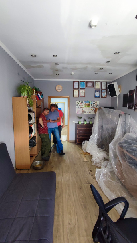 Люди в помещении с поврежденным потолком