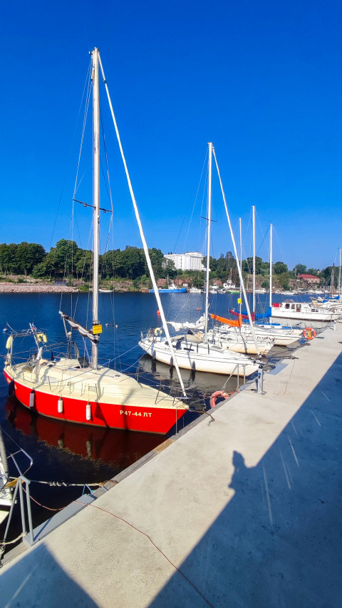 Красная парусная яхта у причала