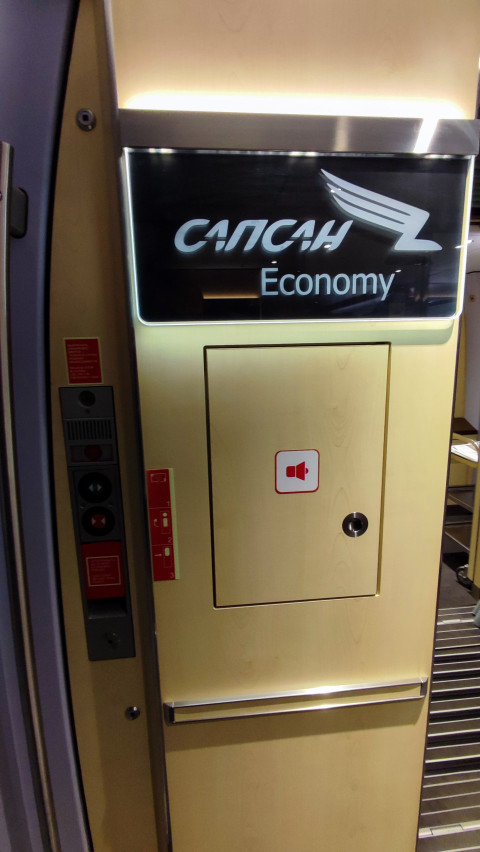 Входная перегородка вагона поезда «Сапсан» с указанием класса Economy