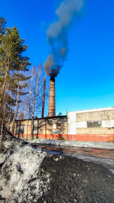 Промышленная котельная с дымящей трубой зимой