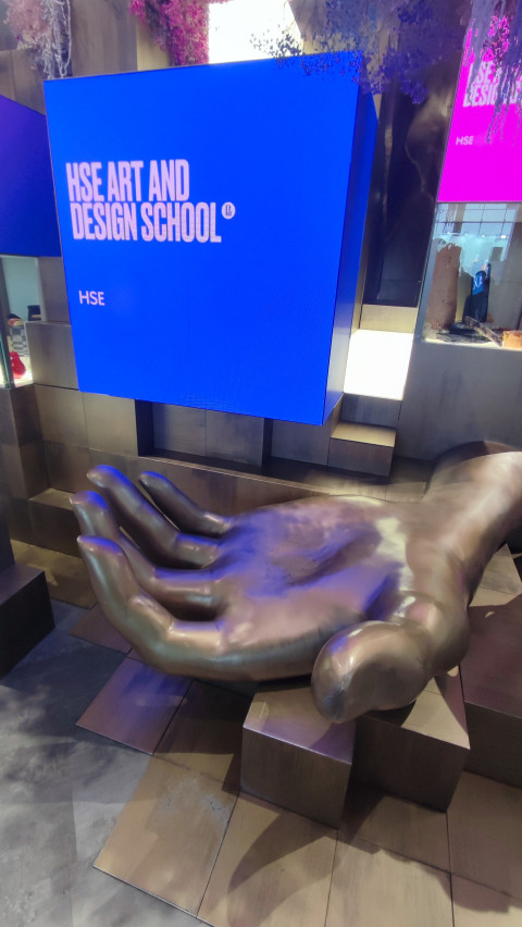 Скульптура ладони под LED-экраном на стенде HSE