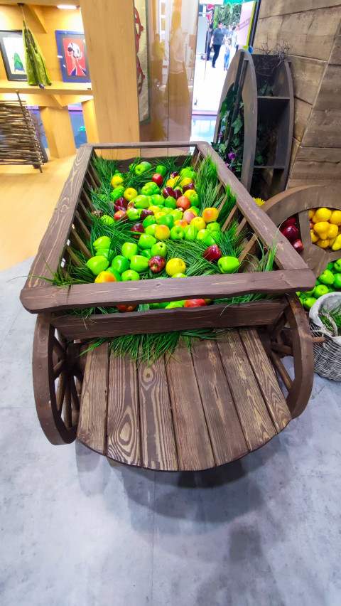 Деревянная телега с декоративными фруктами в выставочном павильоне