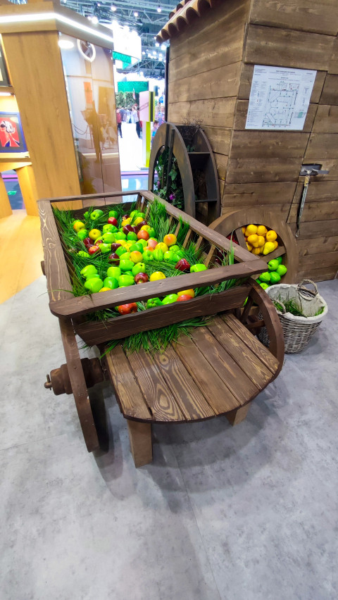 Тележная инсталляция с искусственными яблоками и грушами в павильоне ВДНХ