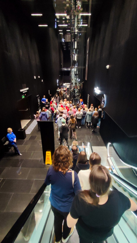 Толпа посетителей у нижнего уровня павильона «Атом» во время спуска по эскалатору