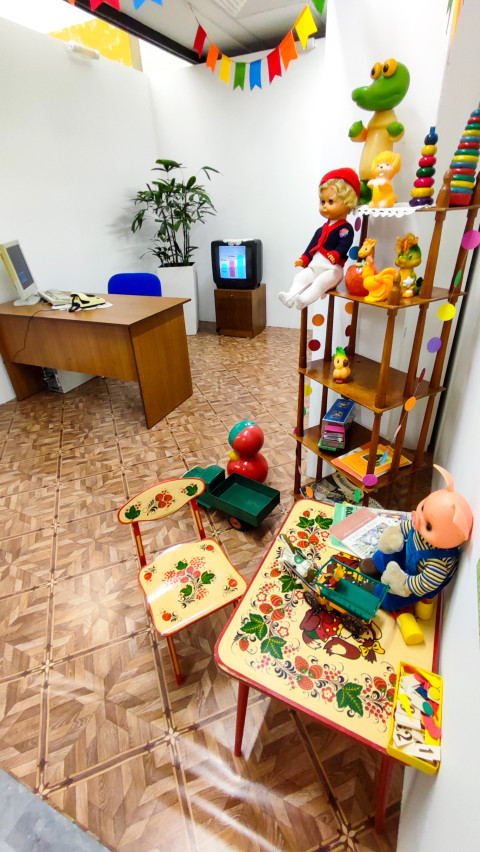 Игровая зона советского стиля с детской мебелью и стеллажом