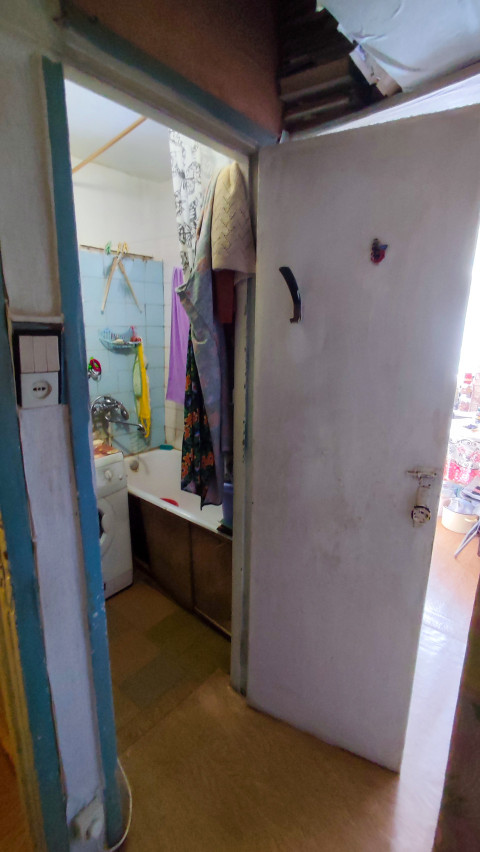 Ванная комната с открытой дверью и стиральной машиной